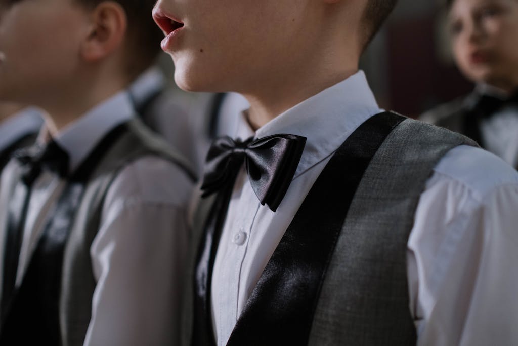 Young boys dressed in formal wear singing in a choir, focused on elegance and unity.